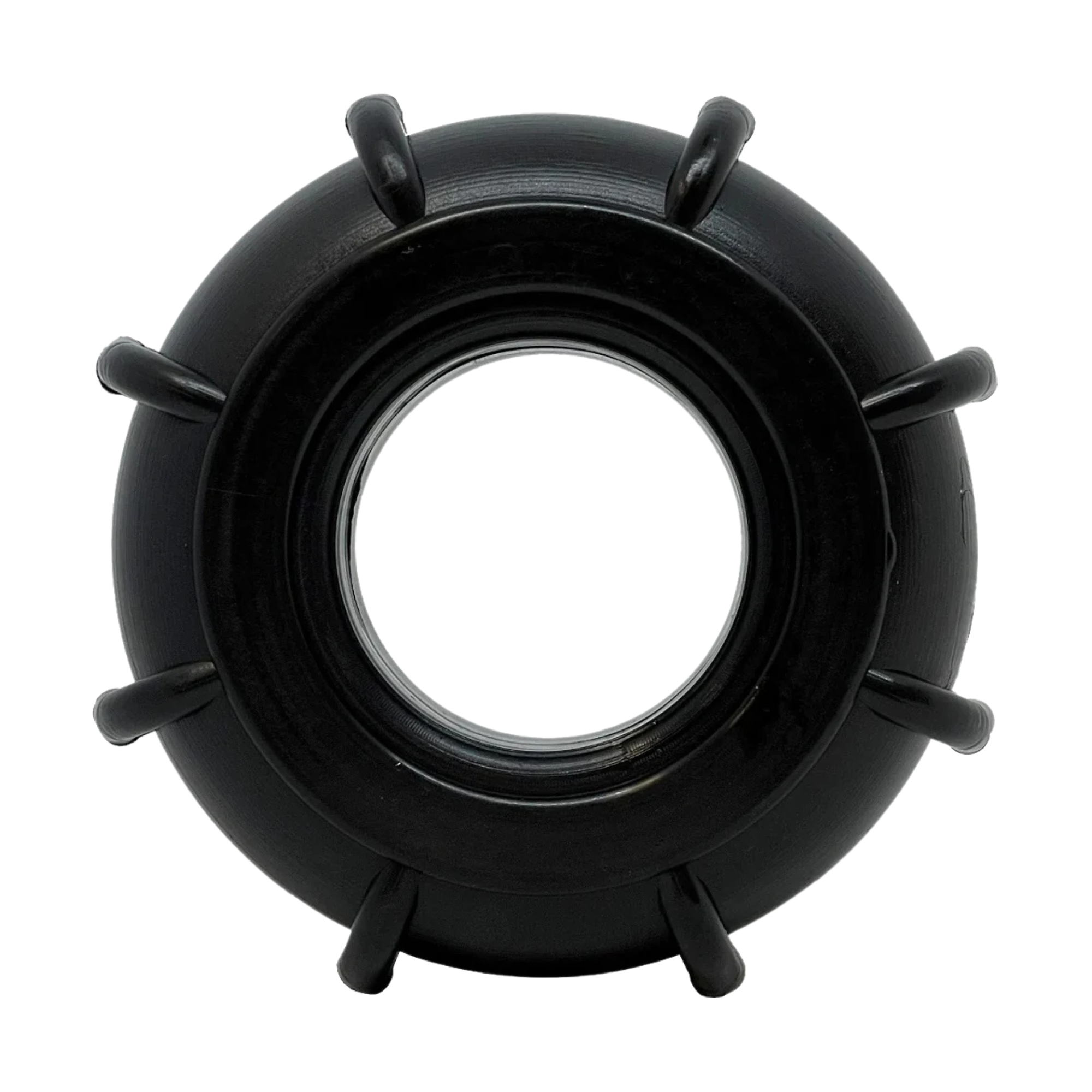 Close-up of a black rubber dog chew toy shaped like a tire with raised edges and a hollow center
