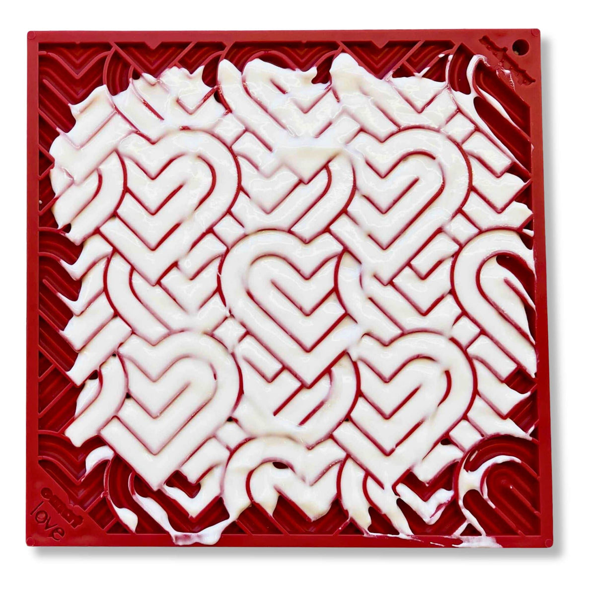 Red heart design enrichment lick mat for dogs with greek yoghurt spread on it&#39;s surface.