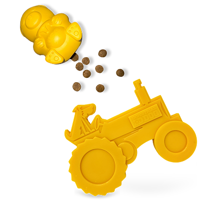 Yellow dog toy shaped like a tractor with small brown treats on a white background