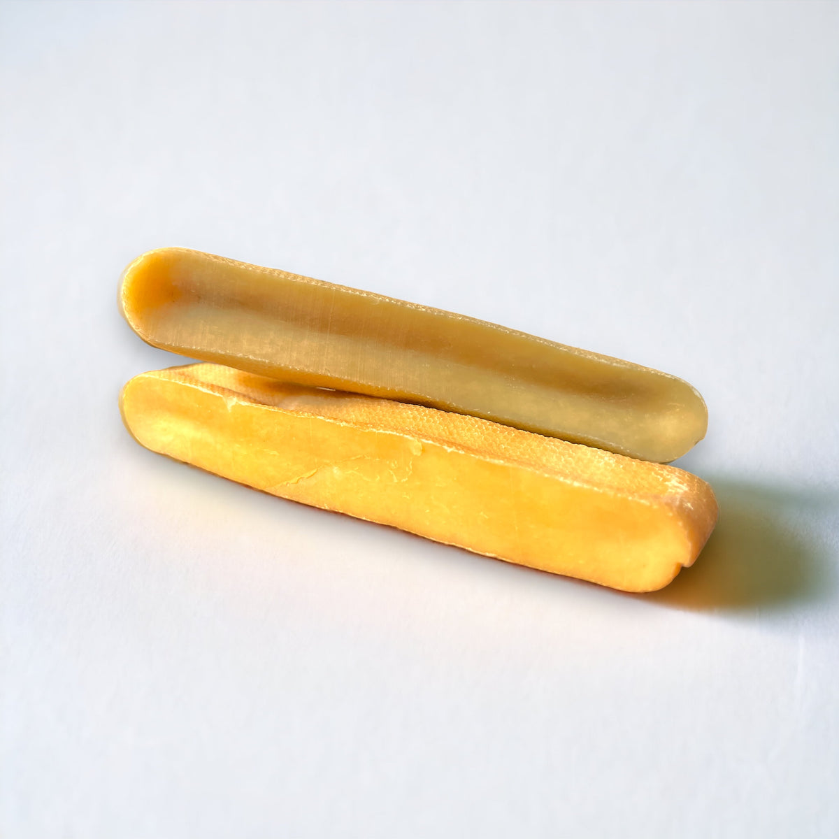 Two natural yak chew dog treats stacked in a neat pile on a white backdrop