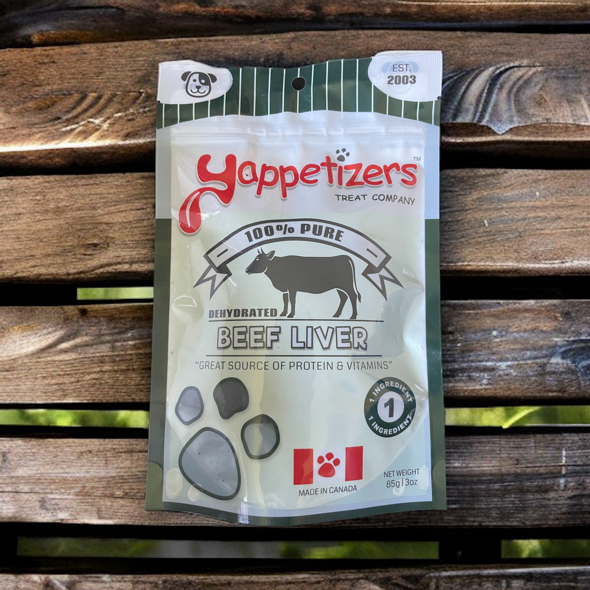 An 85g/3oz bag of natural dehydrated beef liver made in Canada by Yappetizers. The treat bag is on a wooden bench.